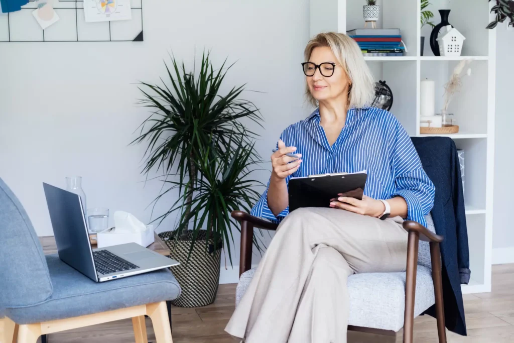 a woman sitting in a chair holding a clipboard