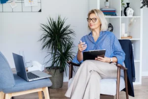 a woman sitting in a chair holding a clipboard
