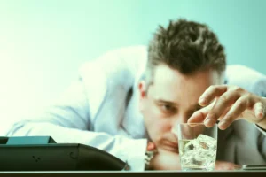 a man reaching for a glass of water