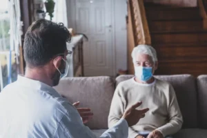 a man wearing a mask talking to a woman