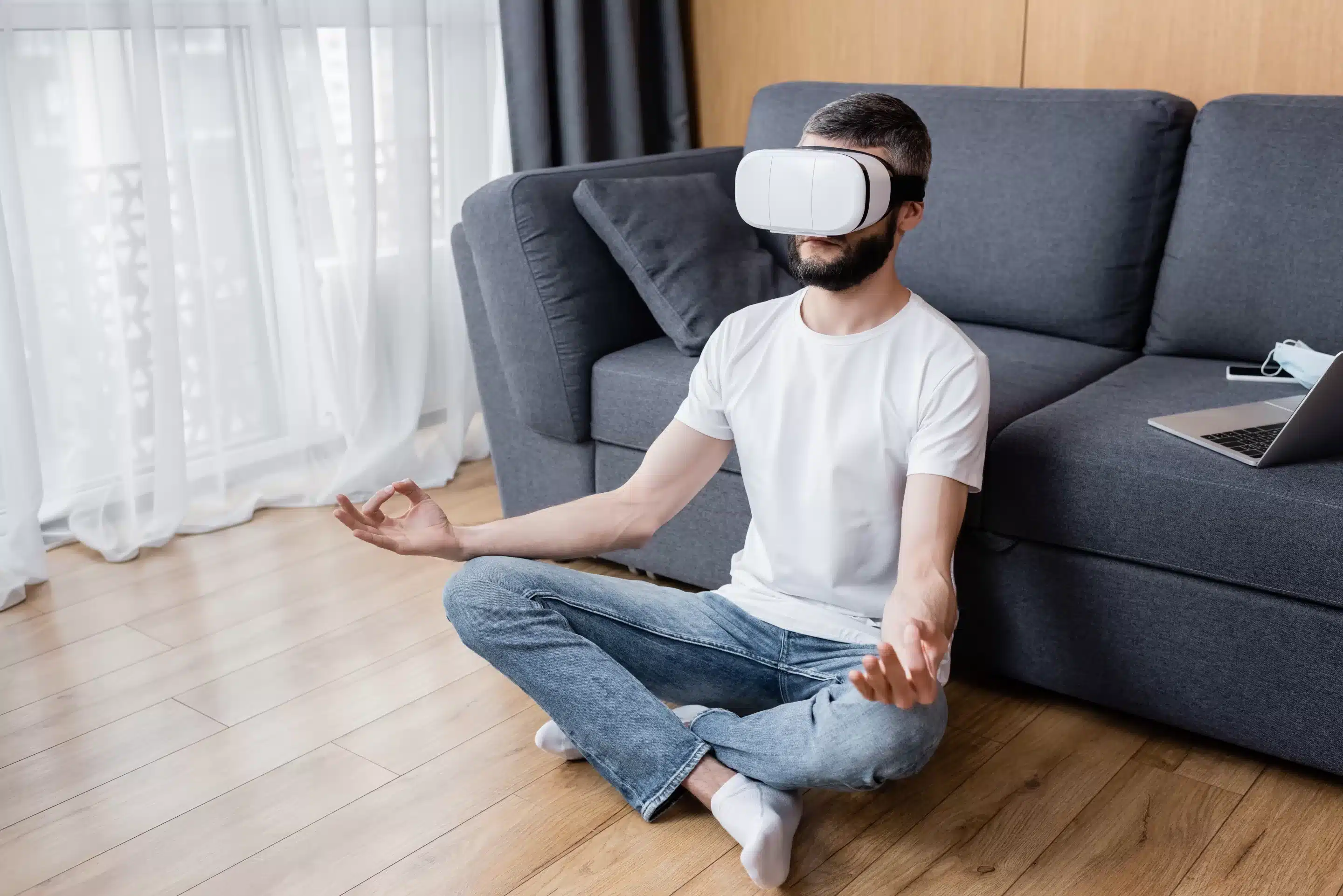 Wearable Devices for Mental Wellness Man in vr headset meditating in lotus pose on floor in living room