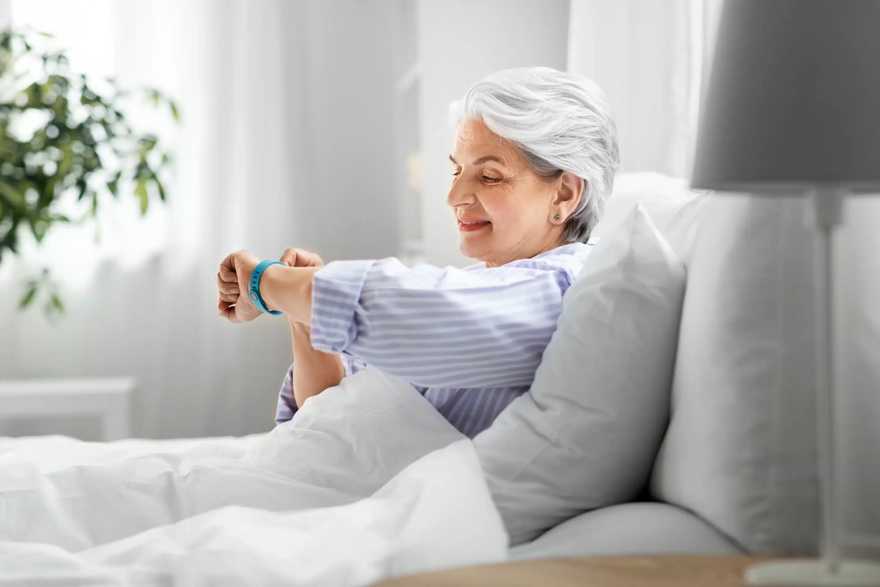 Wearable Devices for Mental Wellness old age and people concept - happy smiling senior woman in pajamas