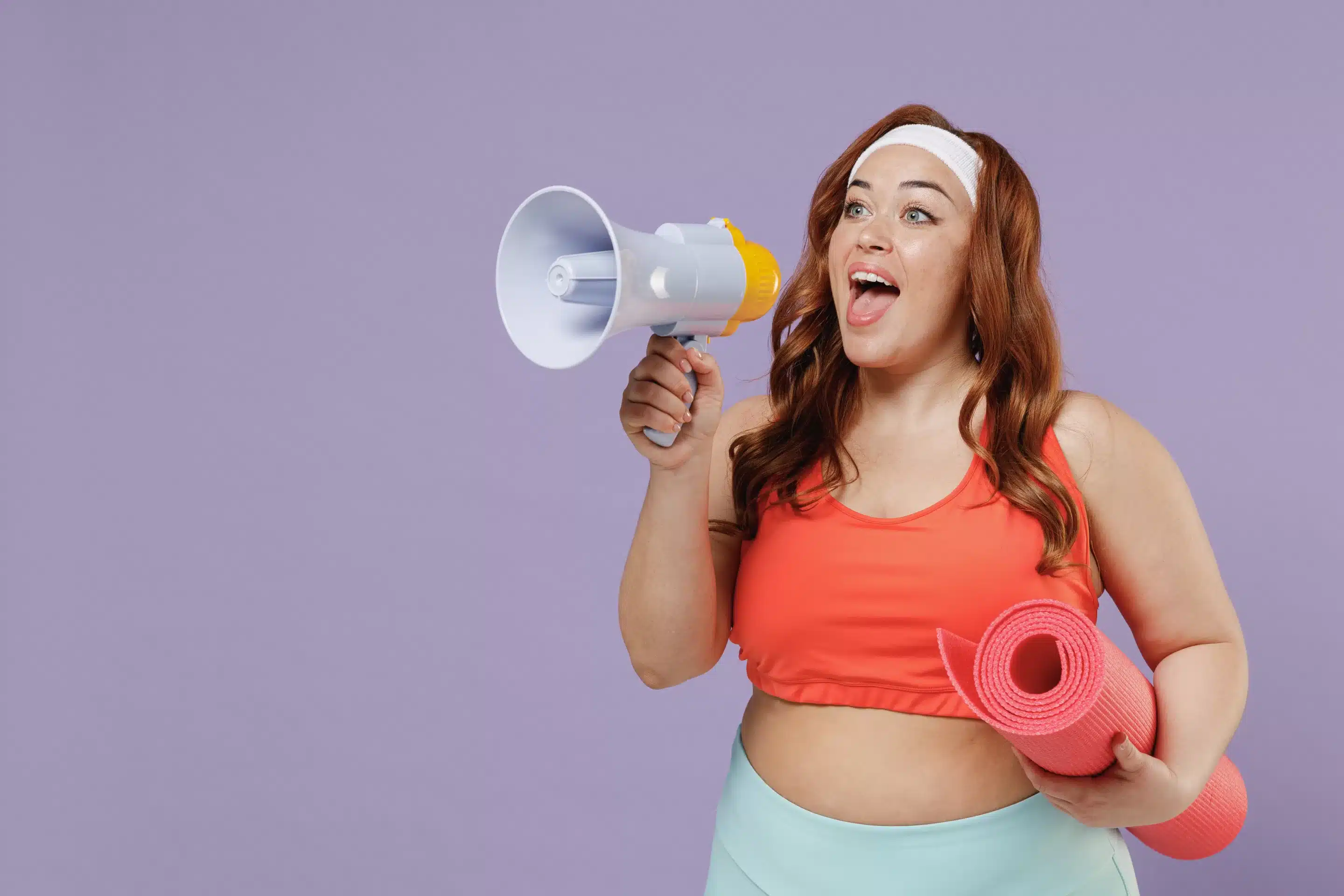 a woman holding a yoga mat and a megaphone