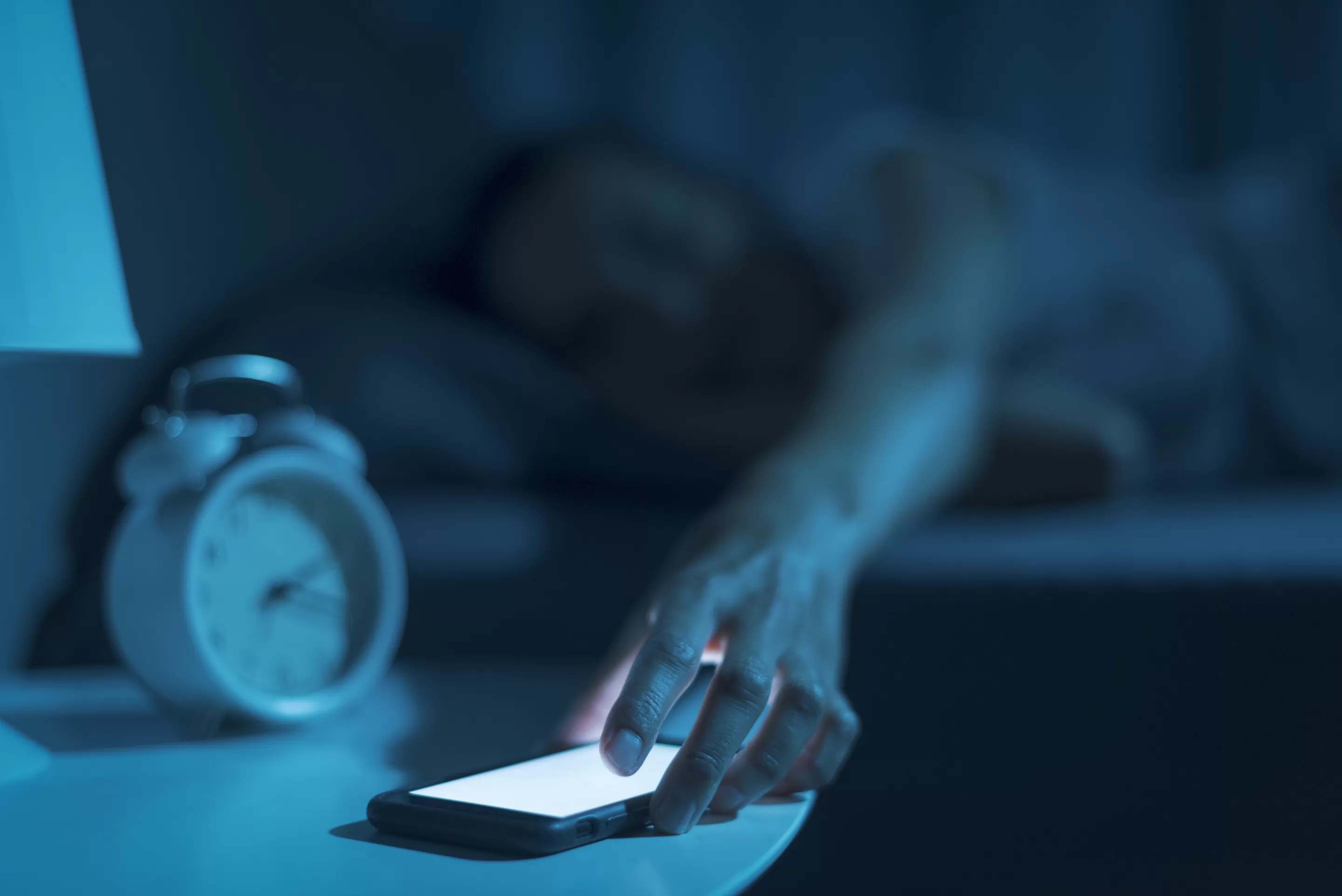 a person lying down in bed with a phone