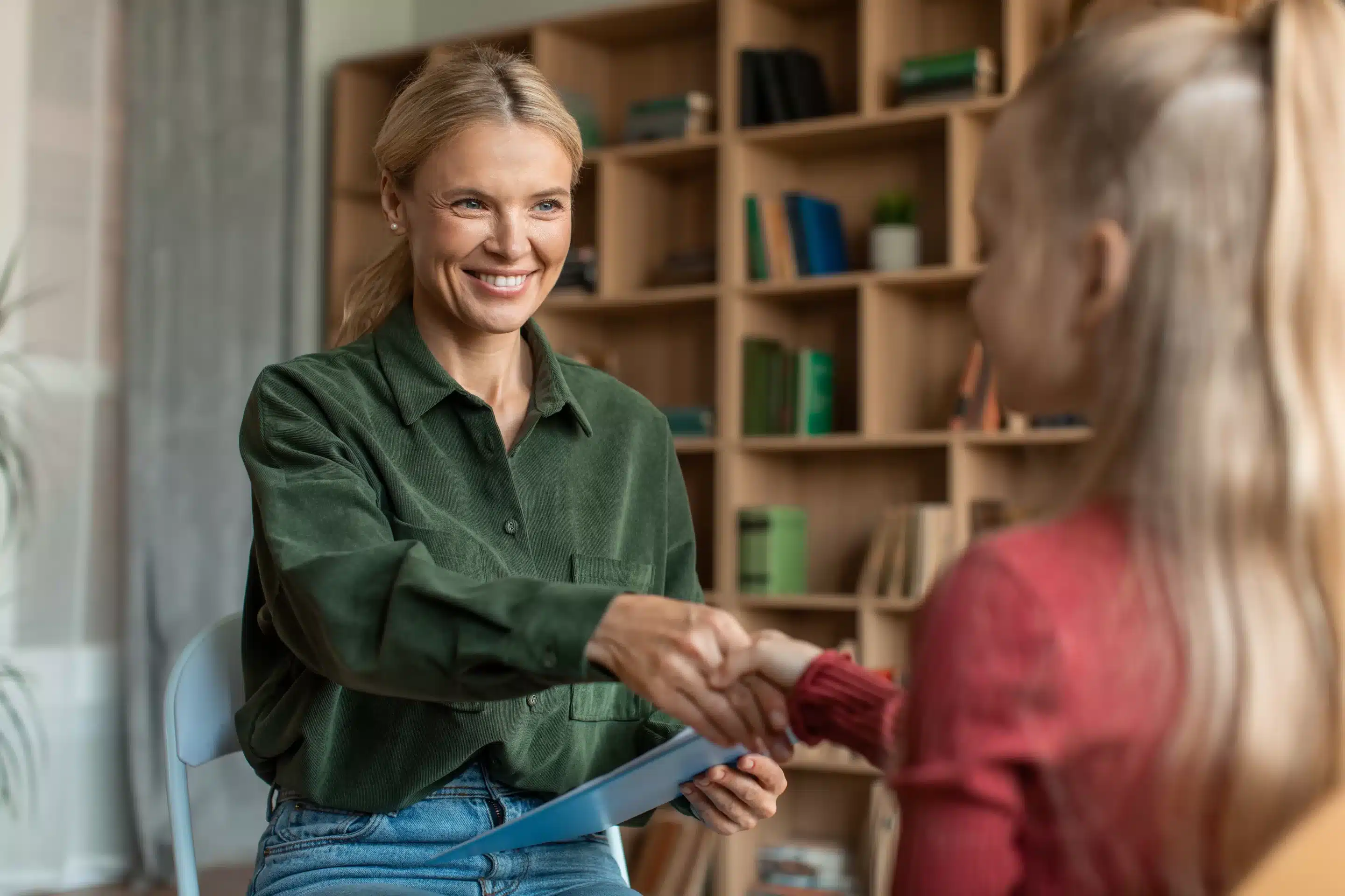 a woman shaking hands with a girl