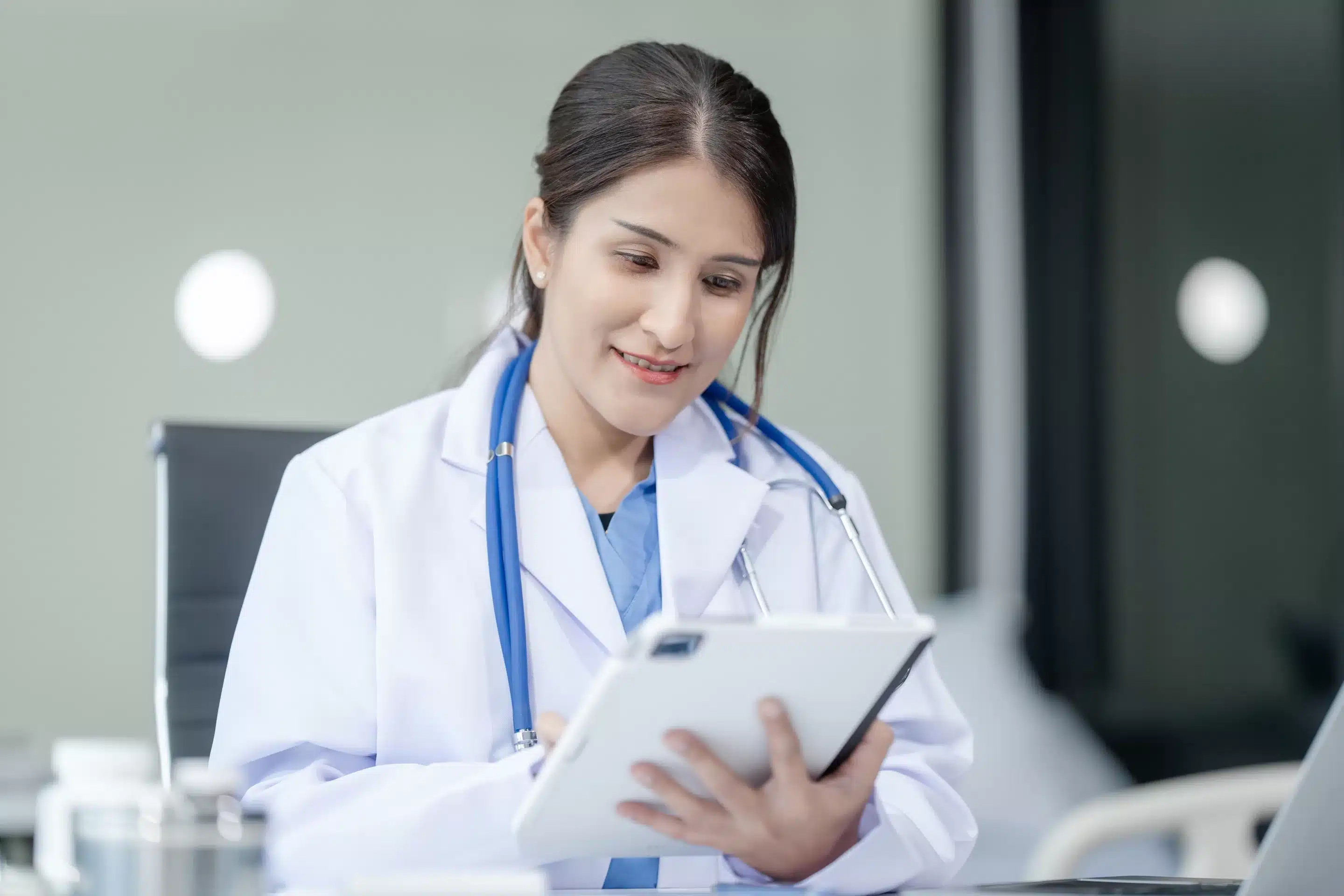 a woman in a white coat holding a tablet
