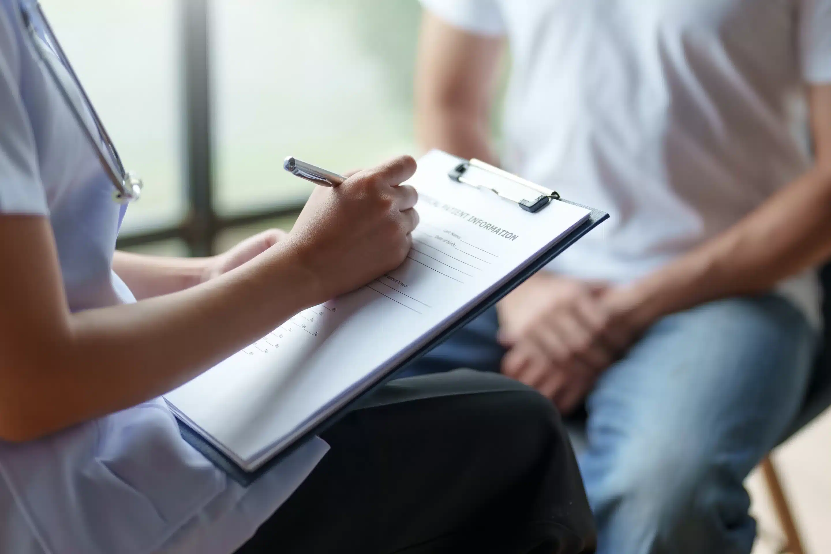 Medical professional writing in notebook regarding a Patients Care