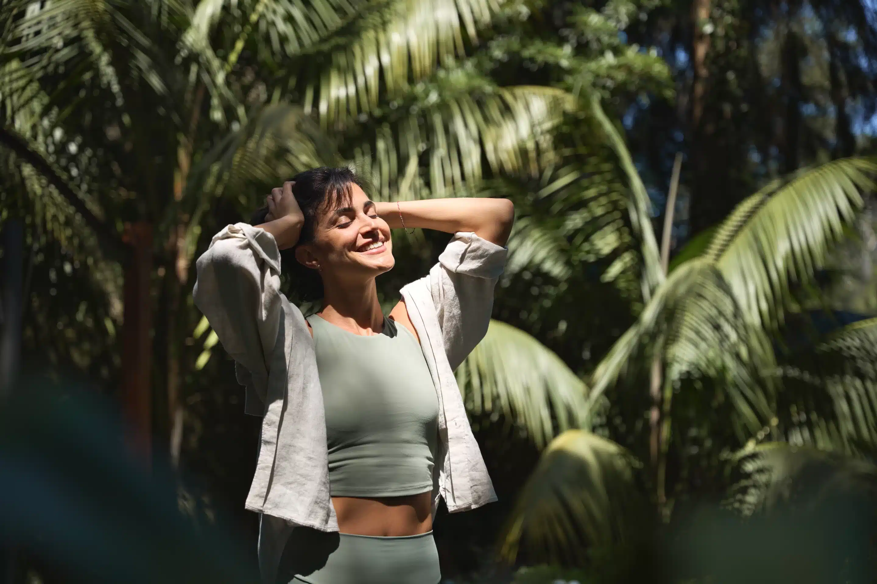 Happy relaxed young Hispanic woman enjoying summer sunny day with eyes closed feeling no stress