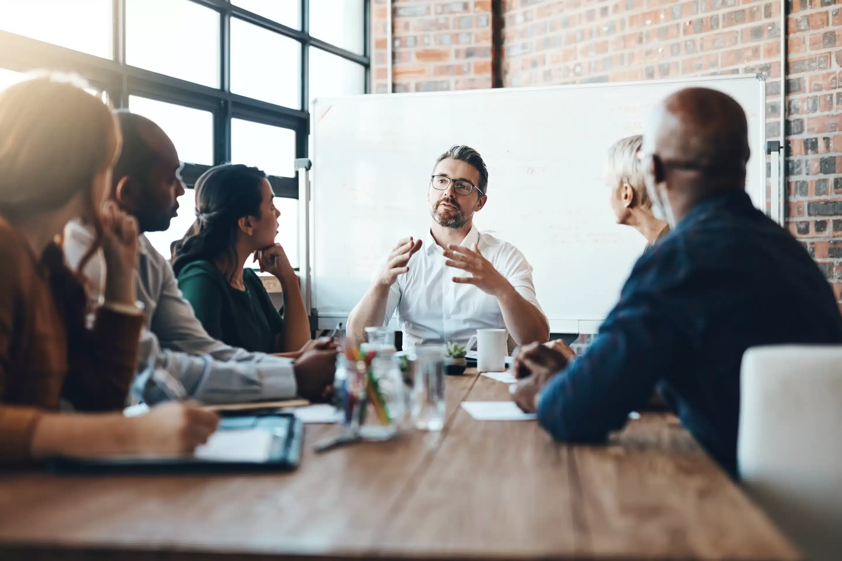 Group of coworkers around a table discussing how to Manage Private Practice