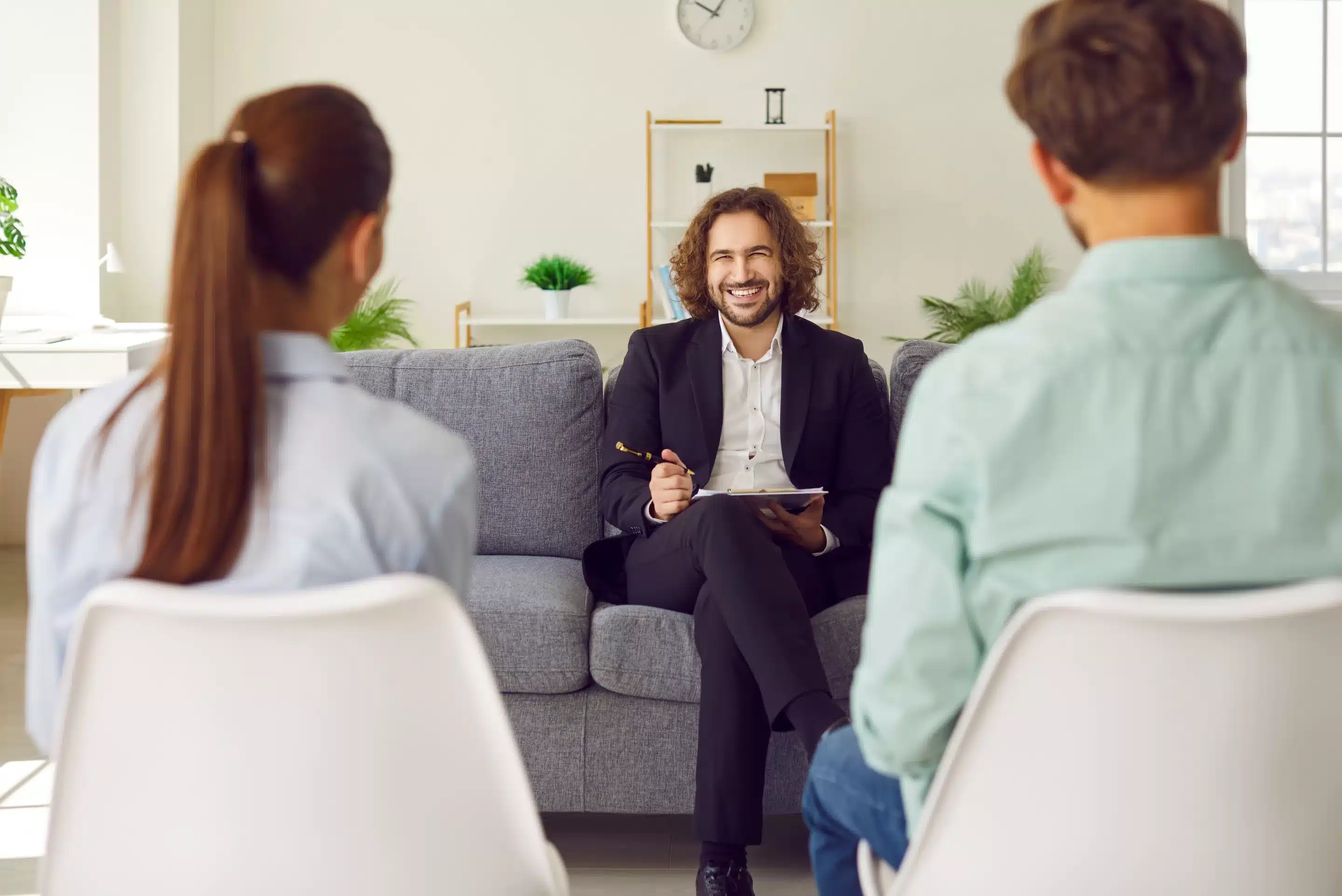 a man sitting on a couch with a couple of people in the background