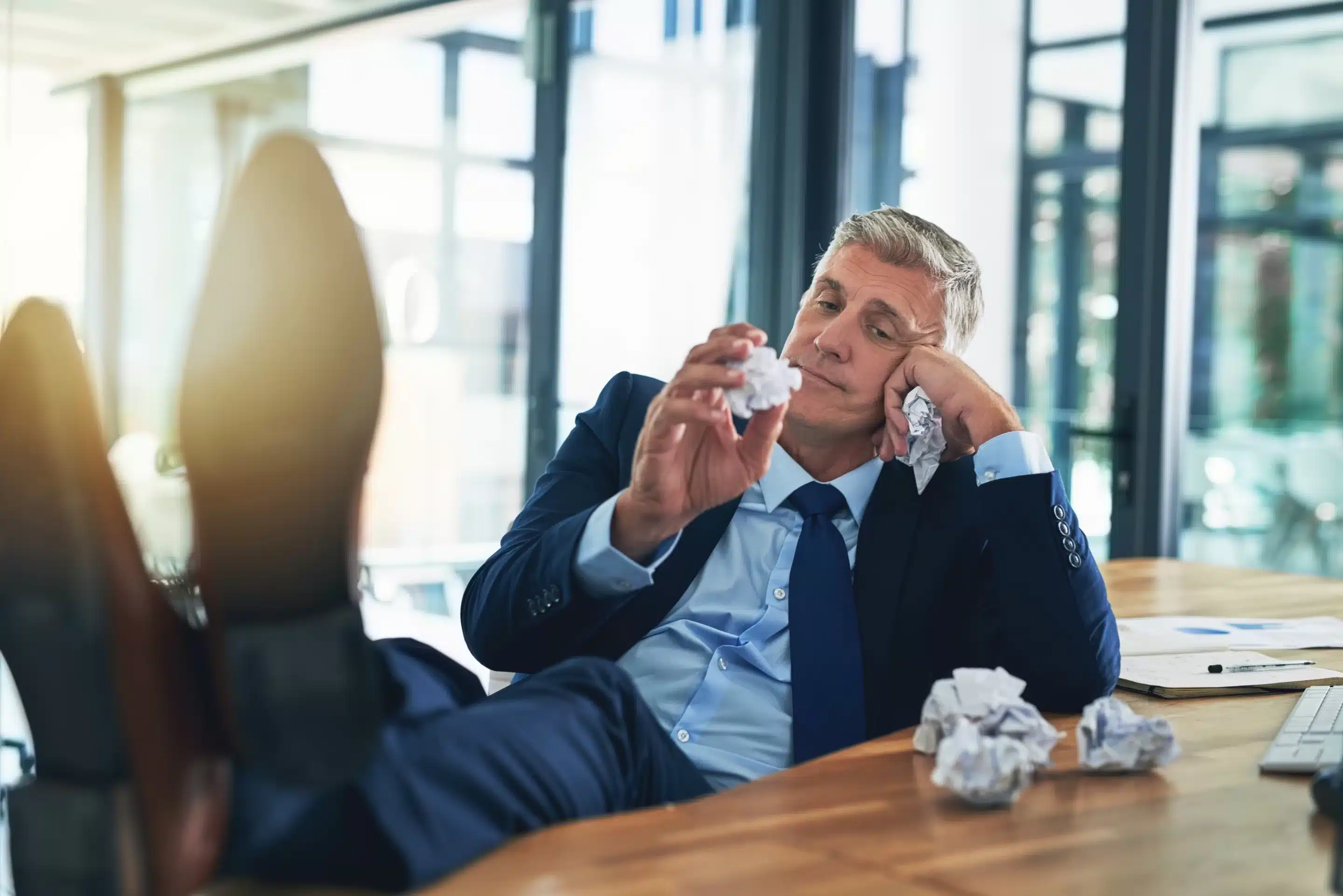 a man in a suit holding crumpled paper