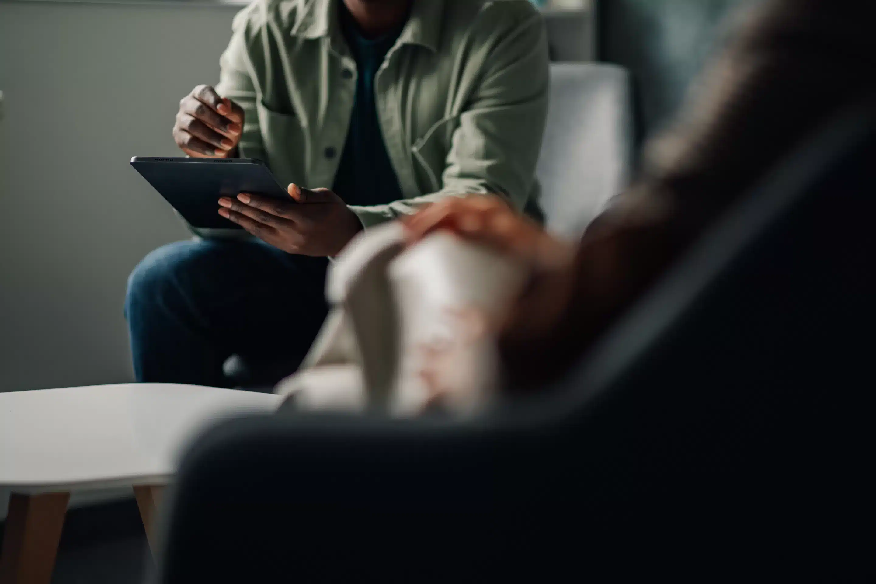 Mental health professional using a tablet to share information with a patient