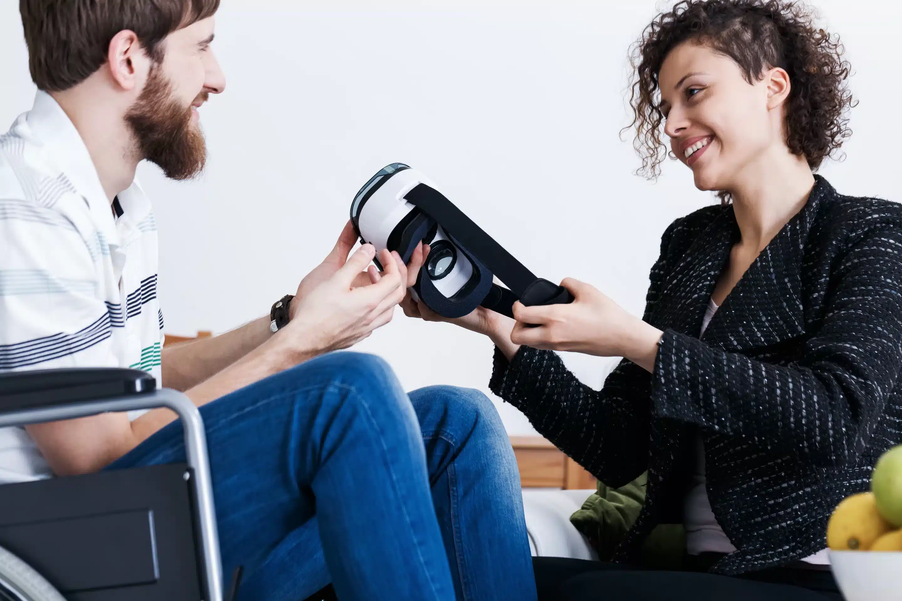 Patient holding virtual reality device during therapy session with assistant 