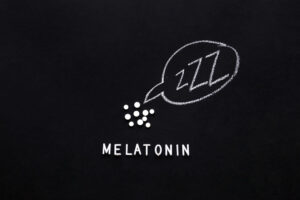 Flat lay composition of melatonin supplements with chalkboard diagram