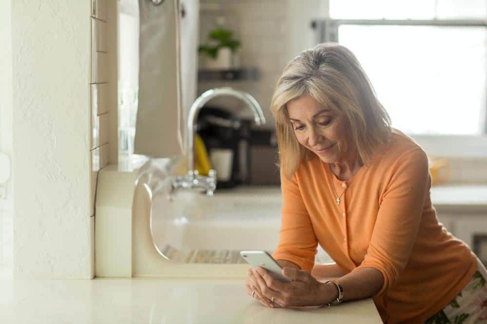 woman in orange long sleeve shirt using white smartphone adhd