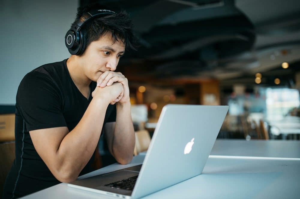 man-wearing-headphones-using-macbook__by-wes-hicks__from-unsplash A Woman in White Coat Using a Macbook